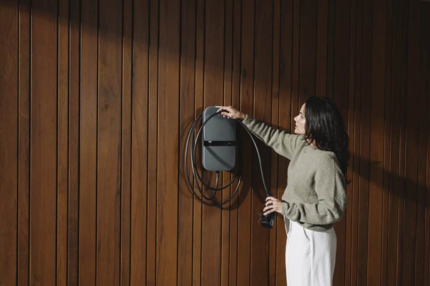 Peblar Home laadpaal gemonteerd aan de gevel van een woning, met een elektrische auto aan de laadkabel